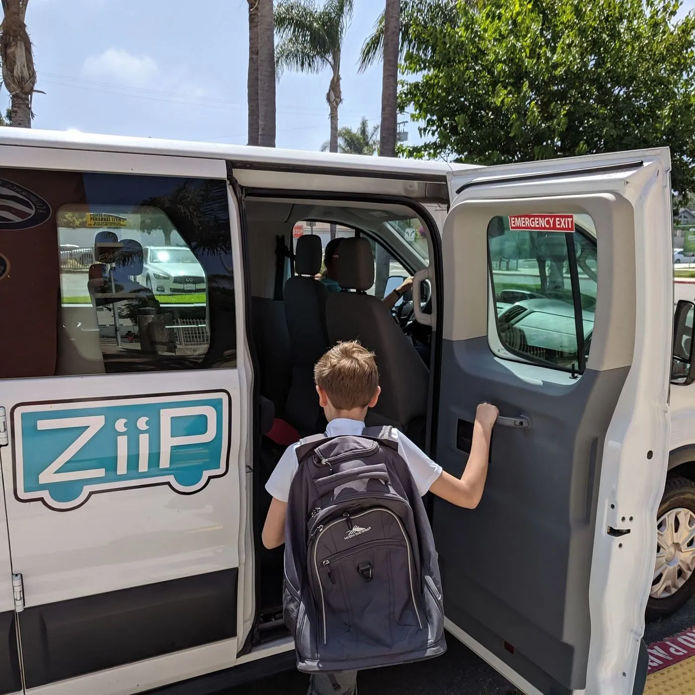 A child with a backpack climbing into a ZiiP van